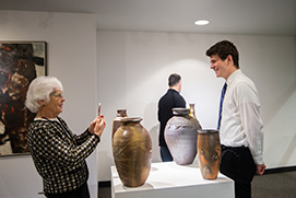 Woman taking a photo of man with pottery. Link to Gifts That Protect Your Assets
