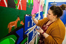 Student painting a mural. Link to Closely Held Business Stock